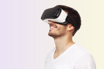Young happy man smiling while enjoying and experiencing virtual reality with VR headset
