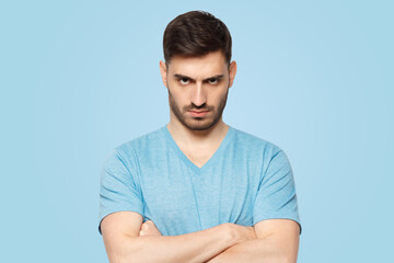 Obraz premium Young aggressive man standing with arms crossed and serious concentrated face