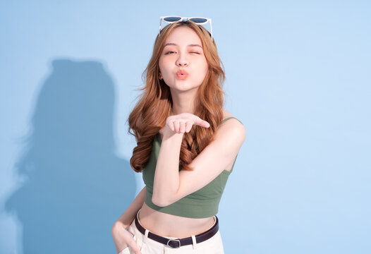 Beautiful young Asian woman on blue background, summer vacation concept