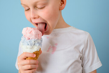 The boy licking ice cream closed his eyes. dirty stain of ice cream on white clothes. daily life...