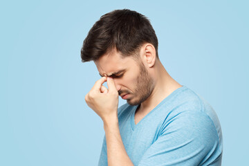 Stressed out young guy making facepalm gesture with hand