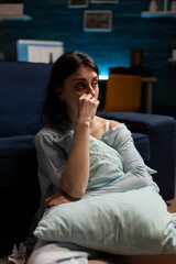 Obraz premium Depressed suicidal woman sitting on living room floor, feeling frustrated and having chronic mental disease difficulties. Anxious female person dealing with sadness and negativity.