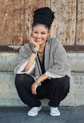 Fashion reflects who you are. Full length shot of a fashionable young woman sitting outside.