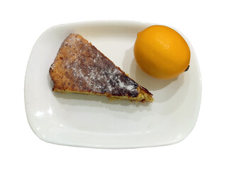 a piece of lemon biscuit and a fresh lemon on a plate, isolated