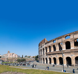 Fototapeta premium Colosseum external view large group of tourists people, copy space on blue sky on top, Rome Italy