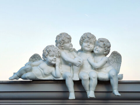sculptures of child angels sitting on the roof