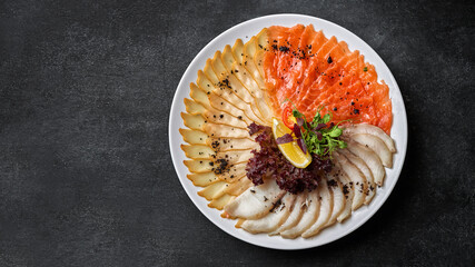 Carpaccio of various fish with lemon. on a plate