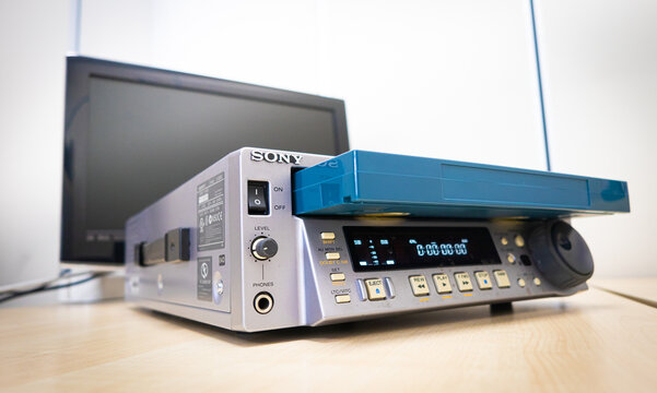 Old betacam pro video player Sony broadcast and editing equipment, tv monitor in background