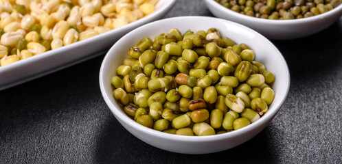 Organics fresh Baby Green Bean Sprouts in white ceramic bowl on a dark concrete background