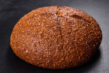 Fresh baked brown bread with ears and grains of wheat