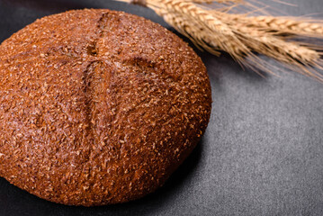 Fresh baked brown bread with ears and grains of wheat