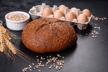 Fresh baked brown bread with ears and grains of wheat