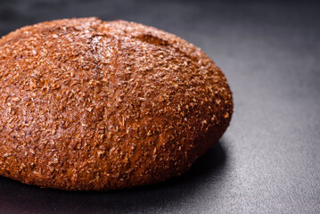 Fresh baked brown bread with ears and grains of wheat