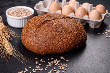 Fresh baked brown bread with ears and grains of wheat