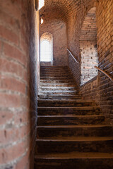 Fototapeta na wymiar Ancient Stone Stairs and Window with Iron Grates, Cremona, Italy