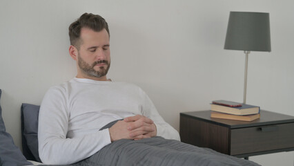 Obraz premium Man Taking Nap while Sitting in Bed