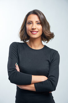 Portrait Of Beautiful Young Woman Smiling, Standing With Arms Crossed Over White Background