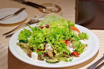 Salad with grilled meat and vegetables and fetta cheese on restaurant table