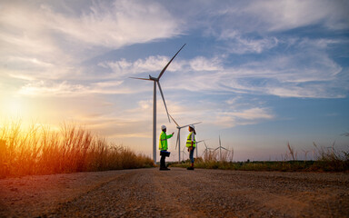 Engineer wearing uniform ,helmet hold document inspection work in wind turbine farms rotation to...
