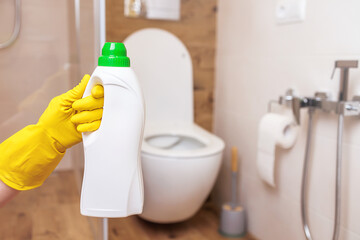 White bottle mockup for toilet sanitizer. Close-up, hand holding bottle of liquid