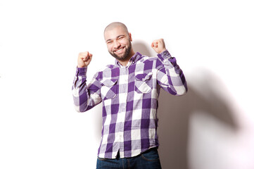 I am winner! Happy young Arabic man looking at camera and gesturing while standing against white background.