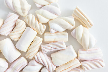 Obraz premium Colorful pastel marshmallow on white background. Ingredient for cooking dessert, snack for movie night and unhealthy sweets. Top view, copy space