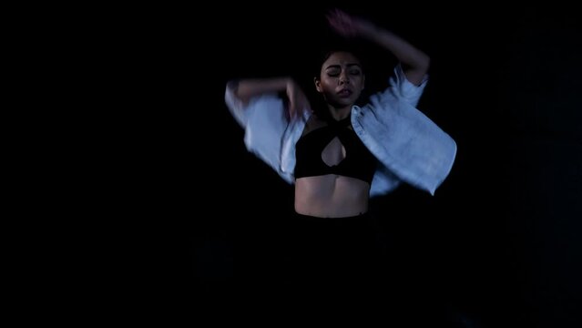 Young Latina Woman Dancing Whacking in Painful Emotional Release in Dramatic Black Background