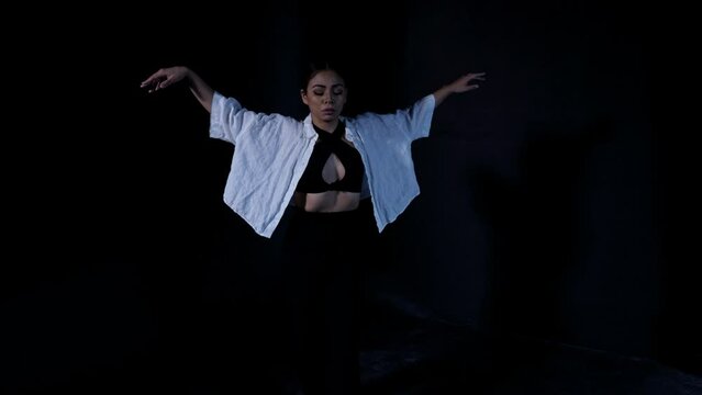 Beautiful Young Woman Dancing Whacking in Serene Release in Dramatic Dark Background