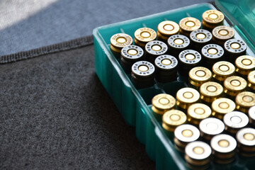 9mm bullet plastic box on dark background, soft and selective focus.