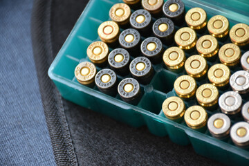 9mm bullet plastic box on dark background, soft and selective focus.