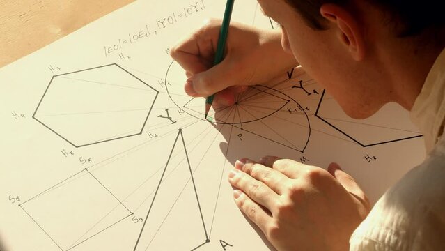 Young mathematician and designer Pavel drawing symmetrical geometric shapes on the paper. Date of shooting day 16 February 2022 year, MSK time. This video was filmed in Russia.