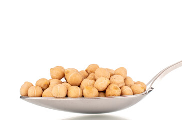 Several uncooked hummus grains with a metal spoon, macro, isolated on white.