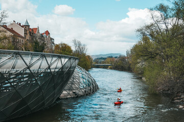 River Mur in Graz, Austria. Bridge over the river in the city. Urban landscape.