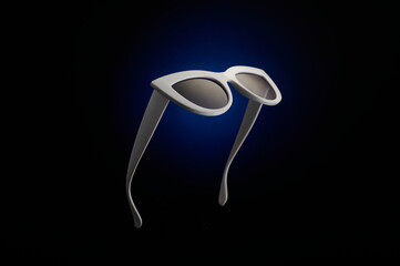 Stylish white sunglasses on a black and blue background.