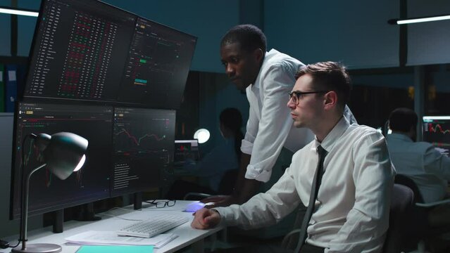 Stressed diverse stock market traders looking at multi-screen computer station with graphs. Brokers loosing invested money on stock market