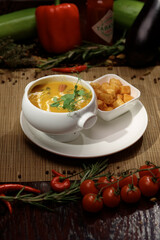 Vertical photography with delicious soup in white plate with crackers.