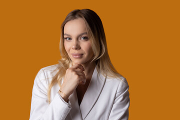 portrait of a stylish businesswoman in a white jacket on a yellow background