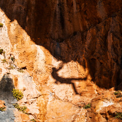 Shadow of a rock climber, climbing on the mountain