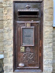 Cookham, England. British Royal Mail post box set in a brick wall, dating from the reign of King...