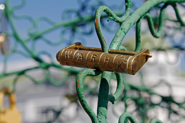 Golden code lock hanging on metal tree closeup outdoors