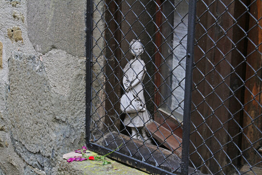 Rupit, Spain - September 09, 2014: Girl statue looking through window guard in Rupit