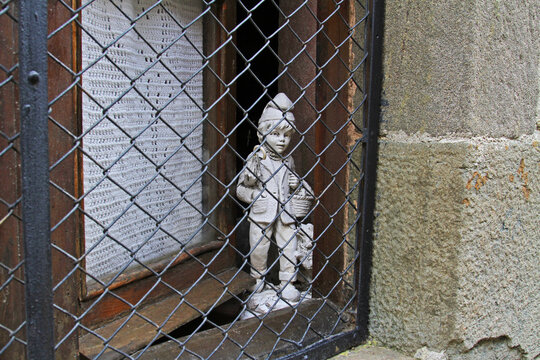 Rupit, Spain - September 09, 2014: Boy and dog statue looking through window guard in Rupit 