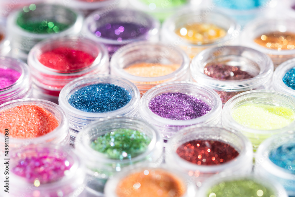Poster jars with colored sequins lie in rows