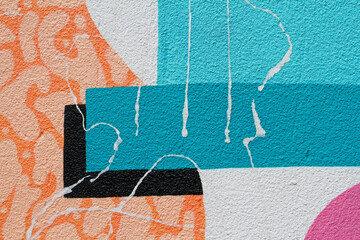 Colorful (orange, black, white, pink and blue) painted wall with paper scraps as background or texture