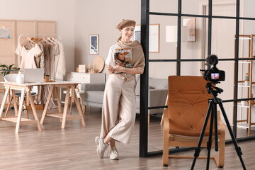 Young female clothes stylist recording video in studio - Powered by Adobe