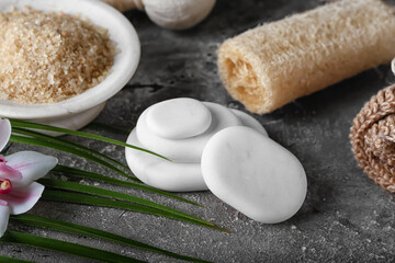 Spa stones with bathing supplies and sea salt on grunge background