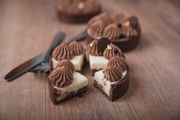 Tarte Schoko-Cheesecake. Feiner Cheesecake mit natürlicher Vanilleschote und einer haube aus Schokolade. Braune Hintergrund