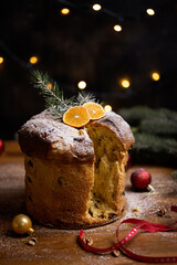 Rustic homemade Christmas traditional Italian holiday panettone cake with festive ribbon, decoration and lights