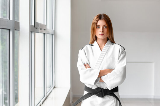Young woman practicing karate in gym