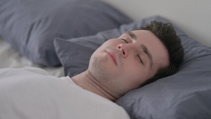 Fototapeta na wymiar Man Sleeping in Bed Peacefully, Close up